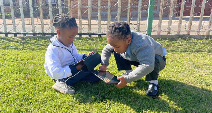 Children learning together on iPads outside